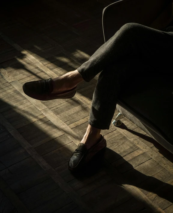 a person's feet sitting on a chair near an open window