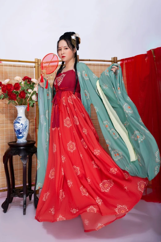 woman dressed in red holding a fan and wearing a dress