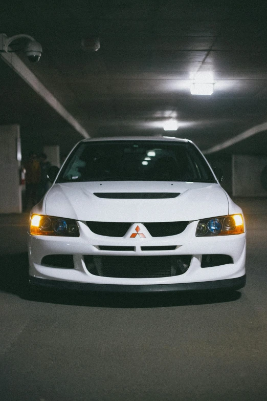 white vehicle in underground parking space with lights on