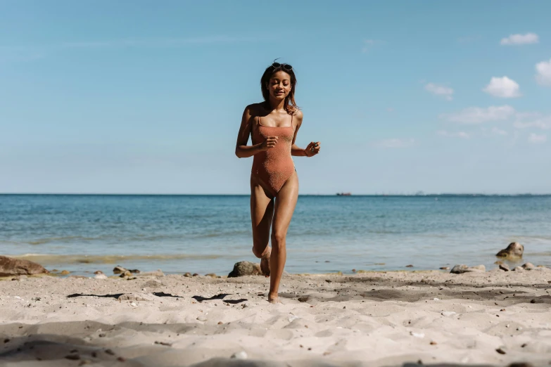 a woman running on a sandy beach at the ocean