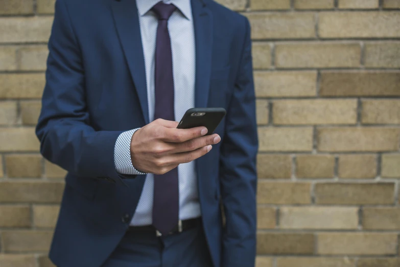 man in suit and tie using a cell phone