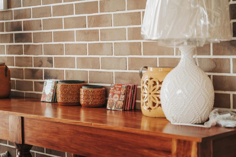 a lamp on top of a wooden shelf near other items