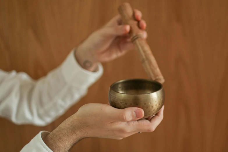 a man is holding his singing bowl while holding the same instrument