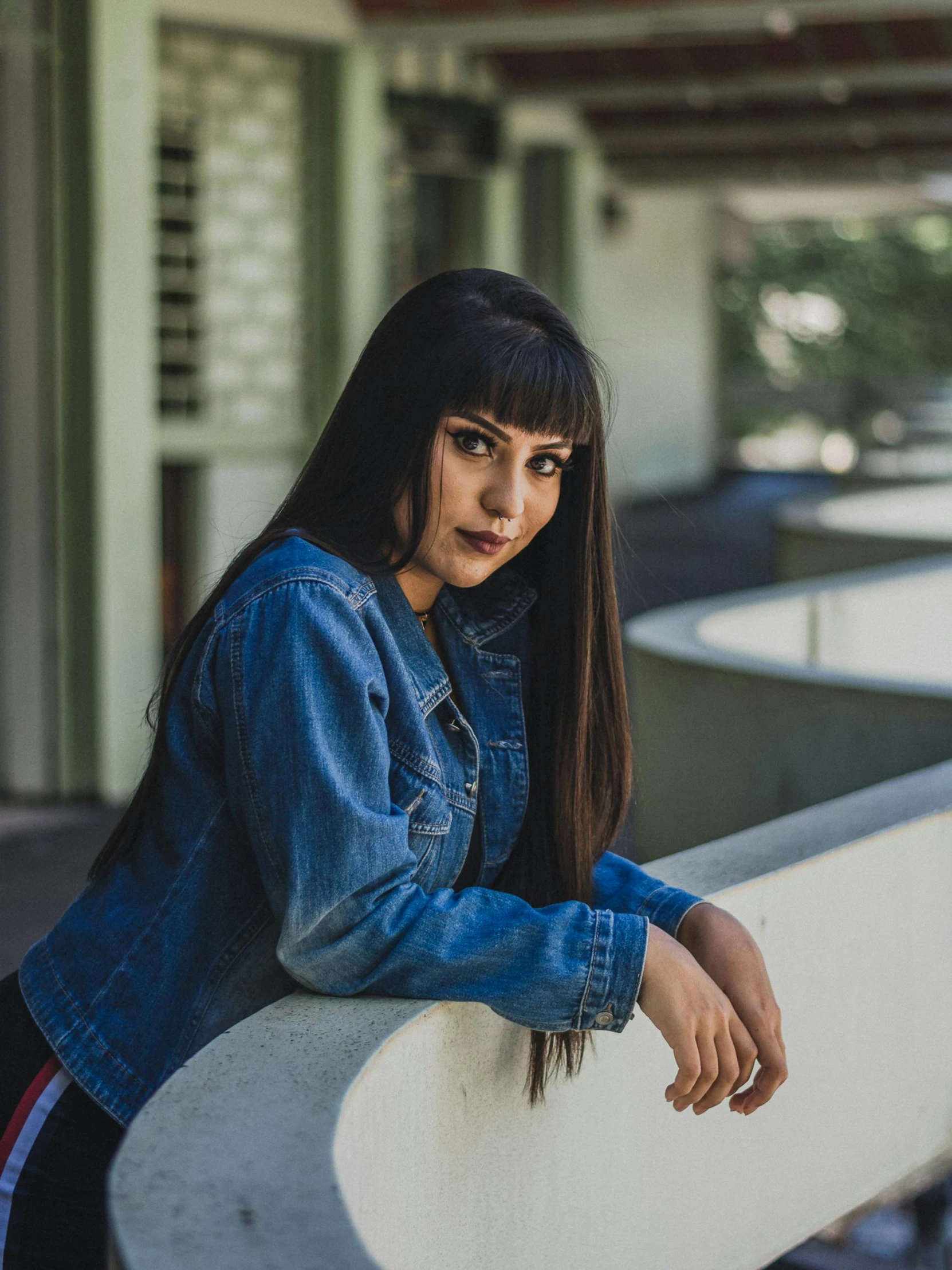 a woman with long hair leans on the side of a wall