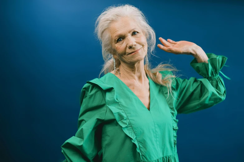 a woman in green dress standing up with hands raised