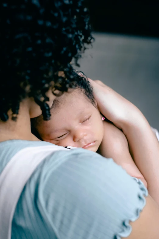 an african american woman holding her newborn baby