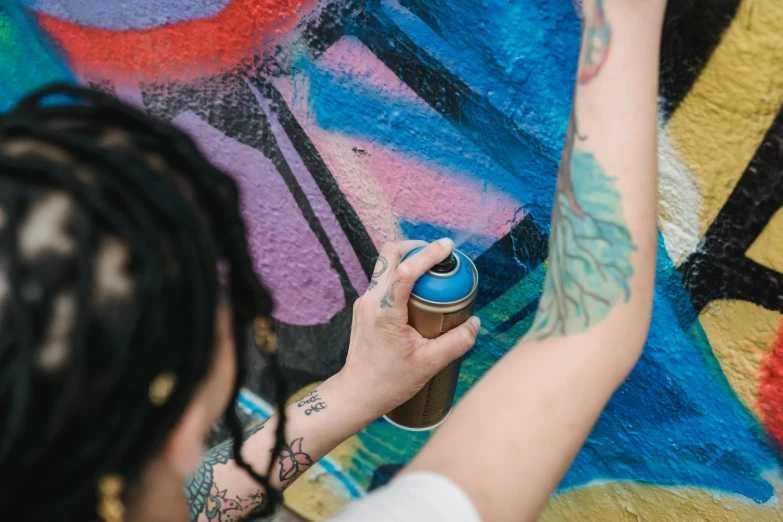 a person spray painting on the ground with graffiti