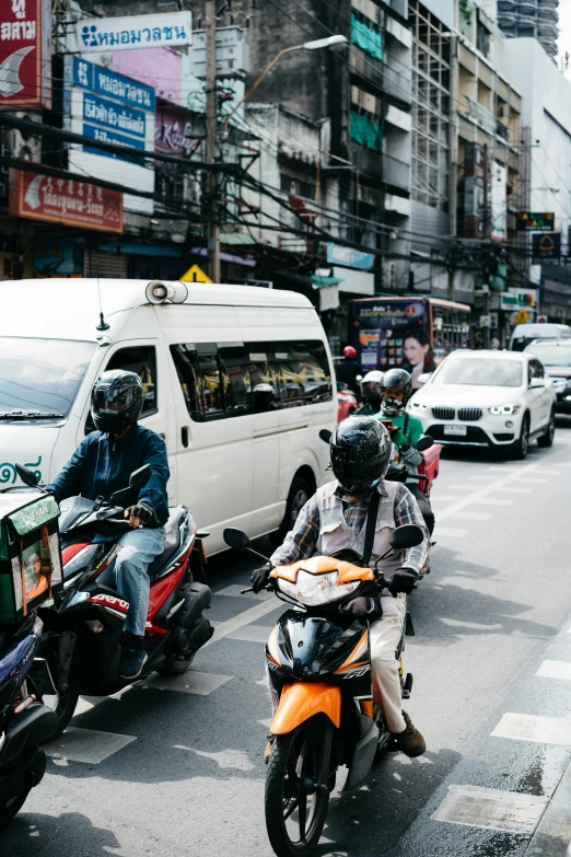 a busy street with motorcycles, cars, and buses