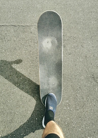 an image of a person standing with their foot on a skateboard