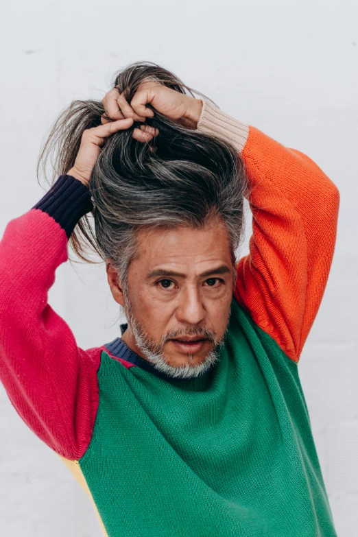 a man is showing off his hair in the studio