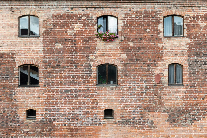 the side of a tall brick building with multiple windows