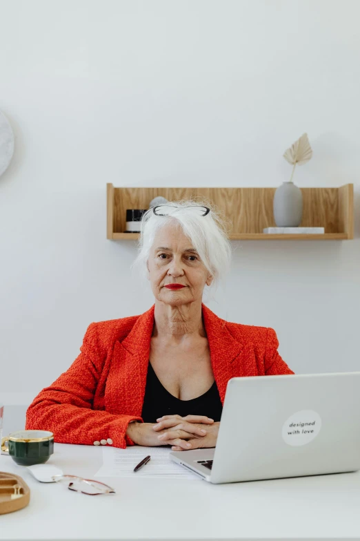 a woman sitting at a table in front of a laptop computer