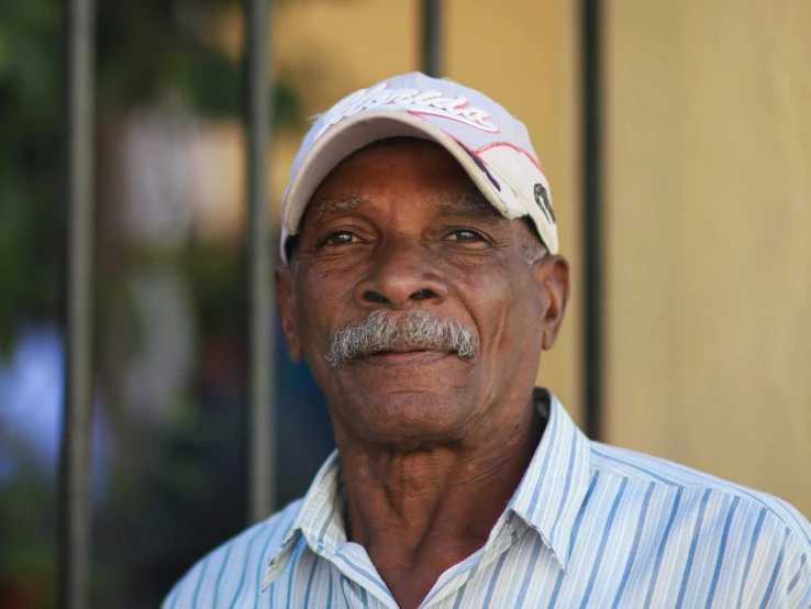 a close - up of an older gentleman wearing a hat with the word,