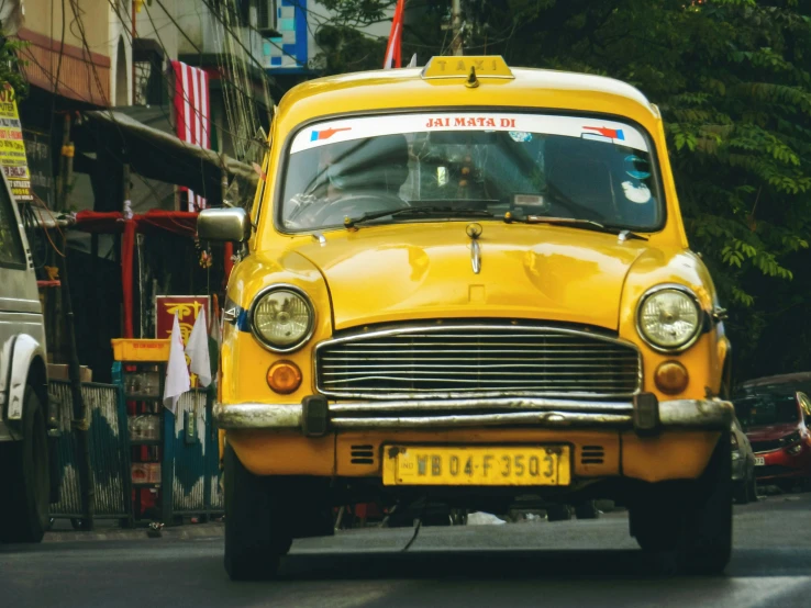 an old fashioned taxi sitting parked on the street