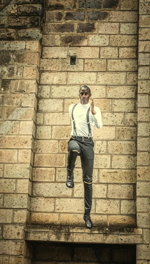 a man is standing up against a brick wall