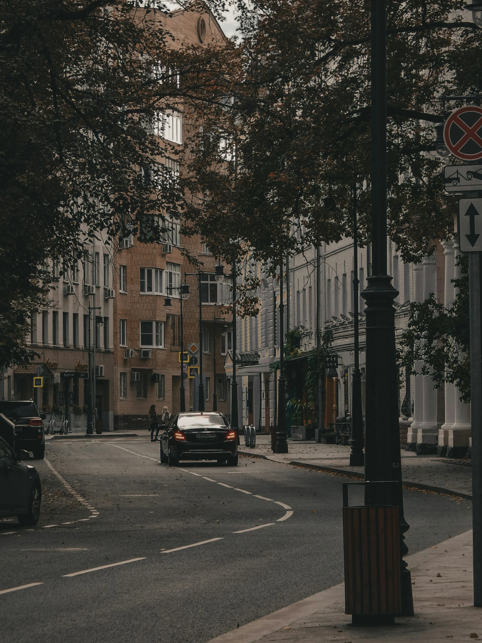 cars and people on the sidewalk in front of a church