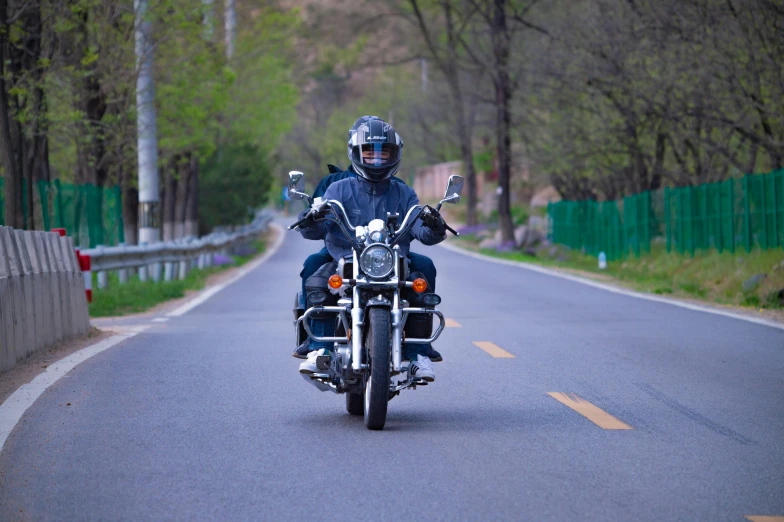 the man is driving a motorcycle on the road