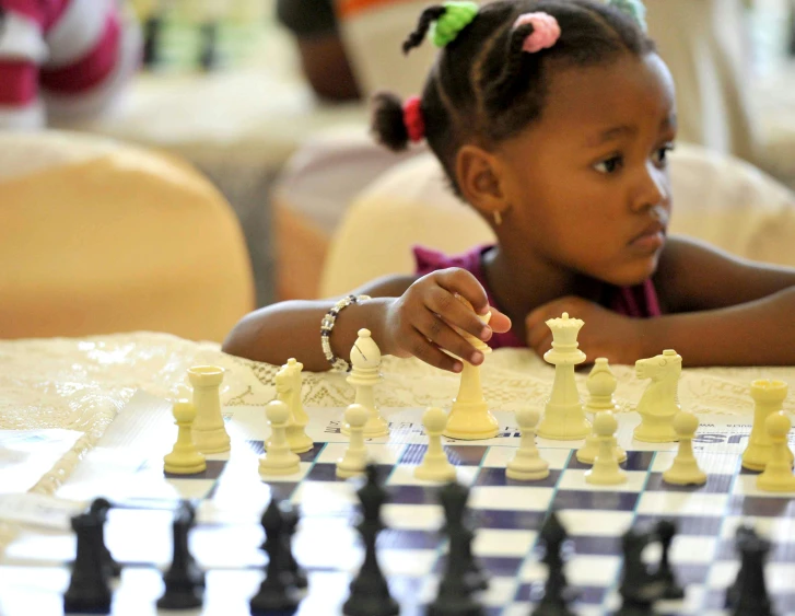 a little girl plays a game of chess