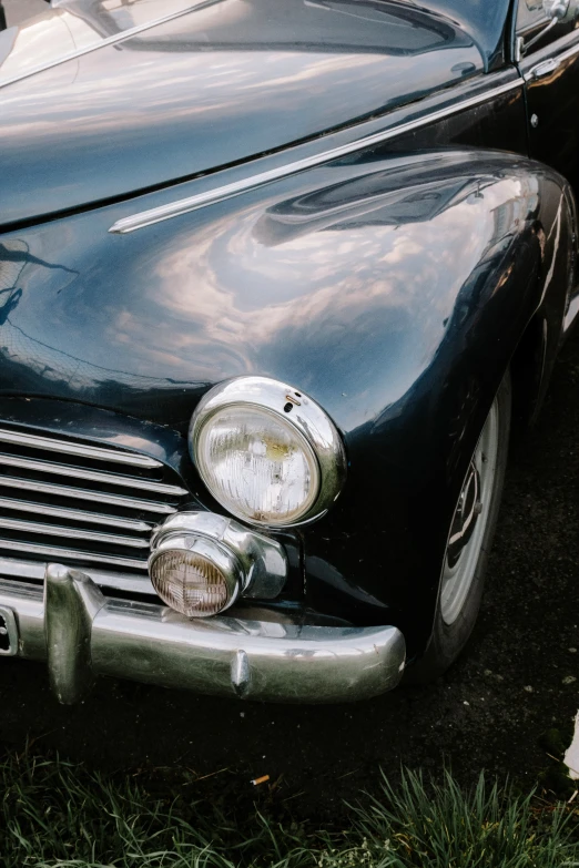 an old, black car sitting on the grass