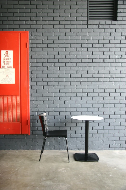 this is a white table and chair in front of a red wall