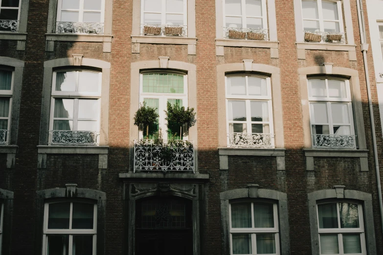 a building with ornate iron railing and balconies is decorated with greenery