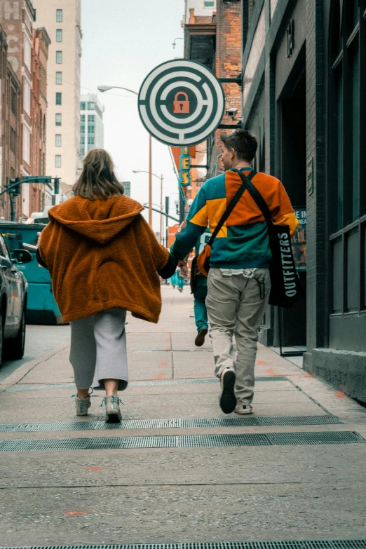 two people walking down the street together holding hands