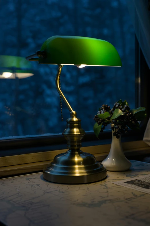 the bright green lamp is beside the vase on the table