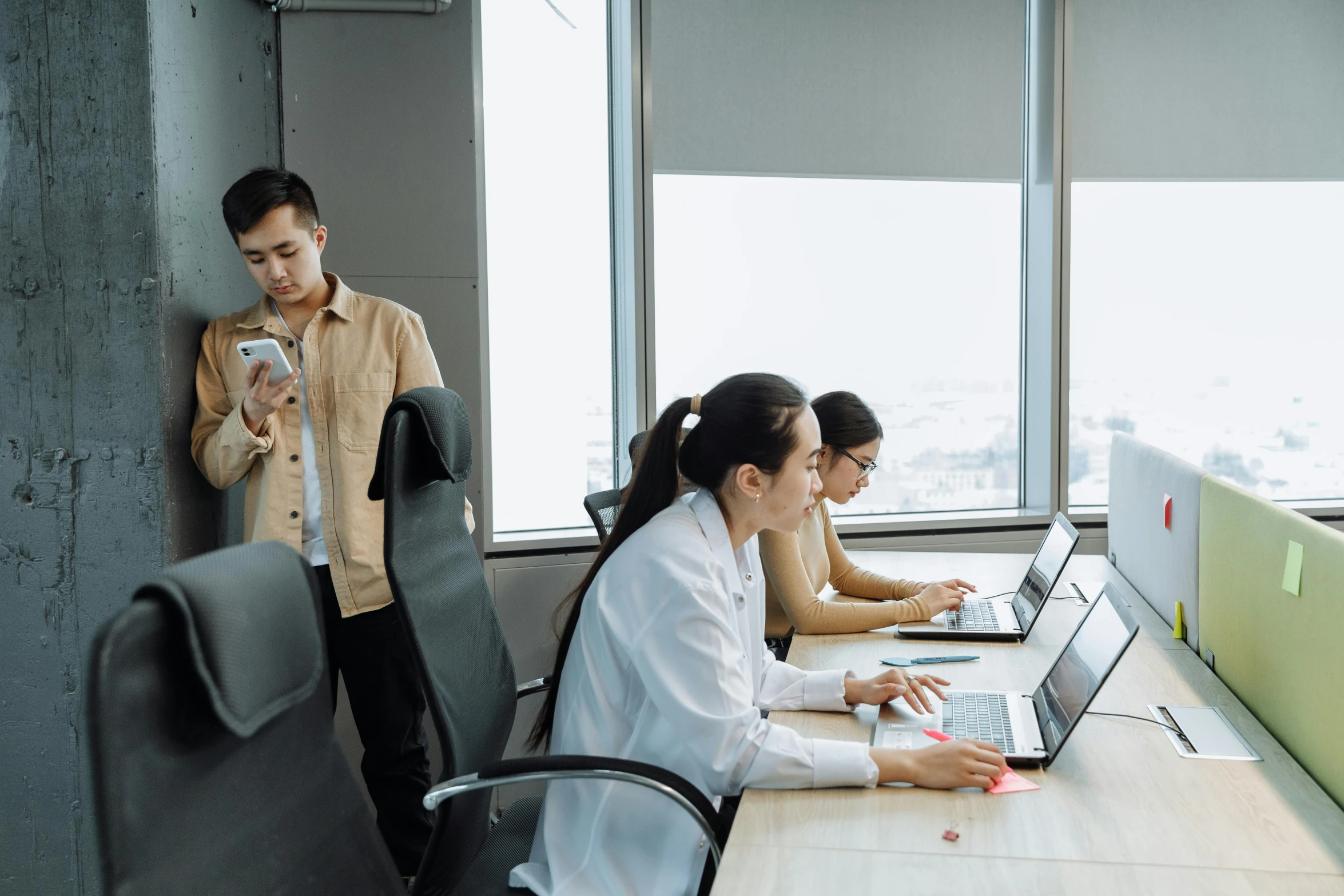 three people sitting at a table with a laptop