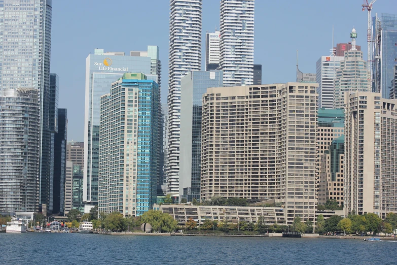 boats sit on a river in front of tall buildings