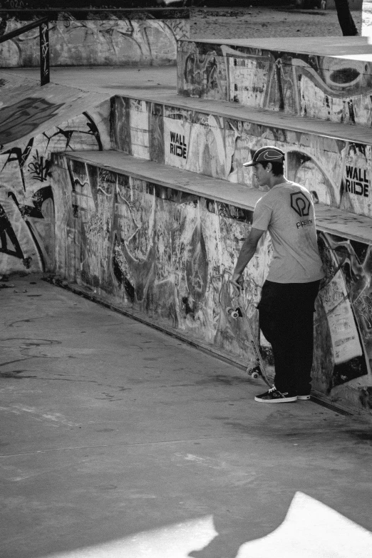 man with two skate boards is near graffiti