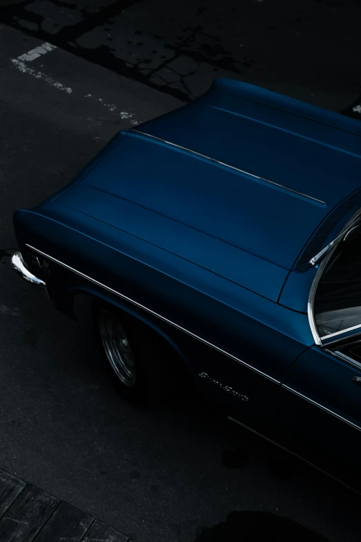 an old model blue car parked on the street