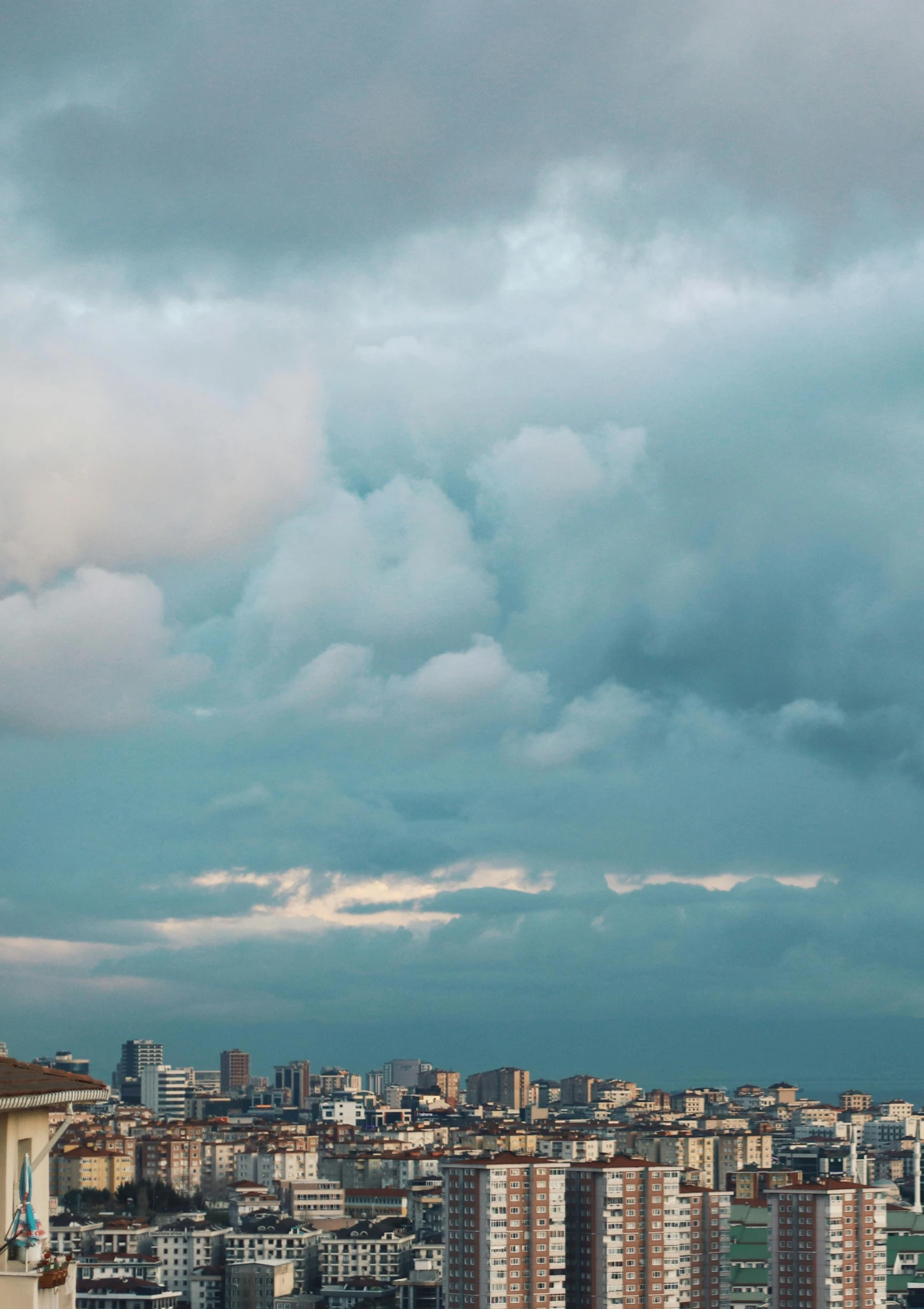 the airplane flies through a cloudy sky over some buildings