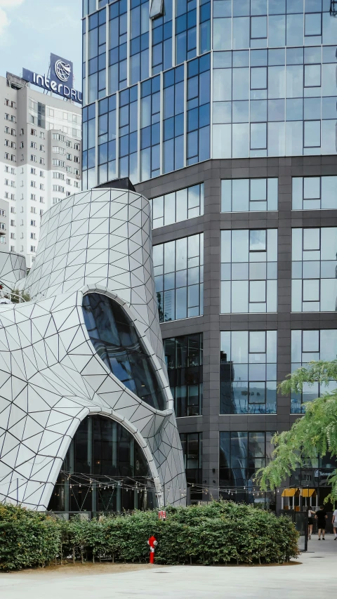 the very large white and black building has a huge fish shaped window
