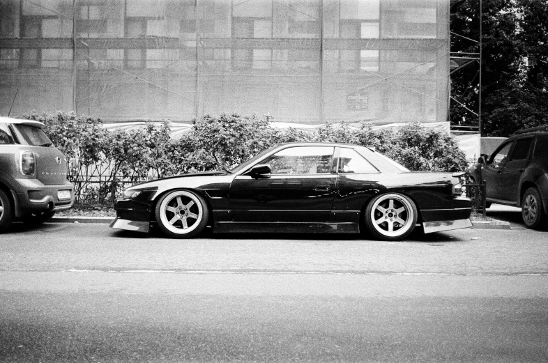 a black and white po of an older car parked in the street