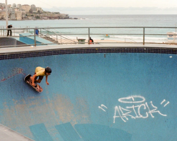 a man riding up the side of a ramp on top of a skateboard