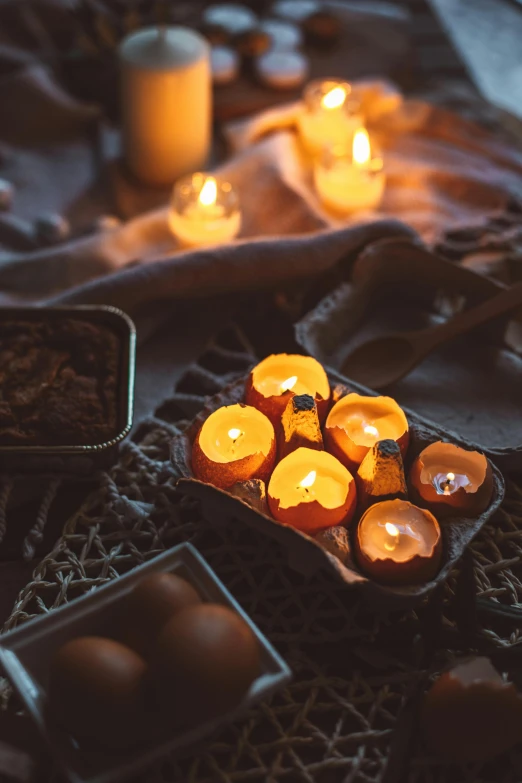 several tea light candles in an old tray on a table