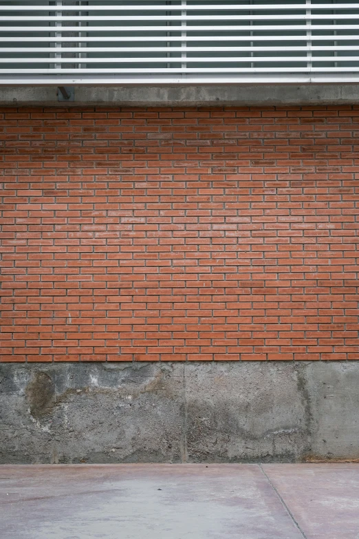 a fire hydrant sitting next to a building with a brick wall