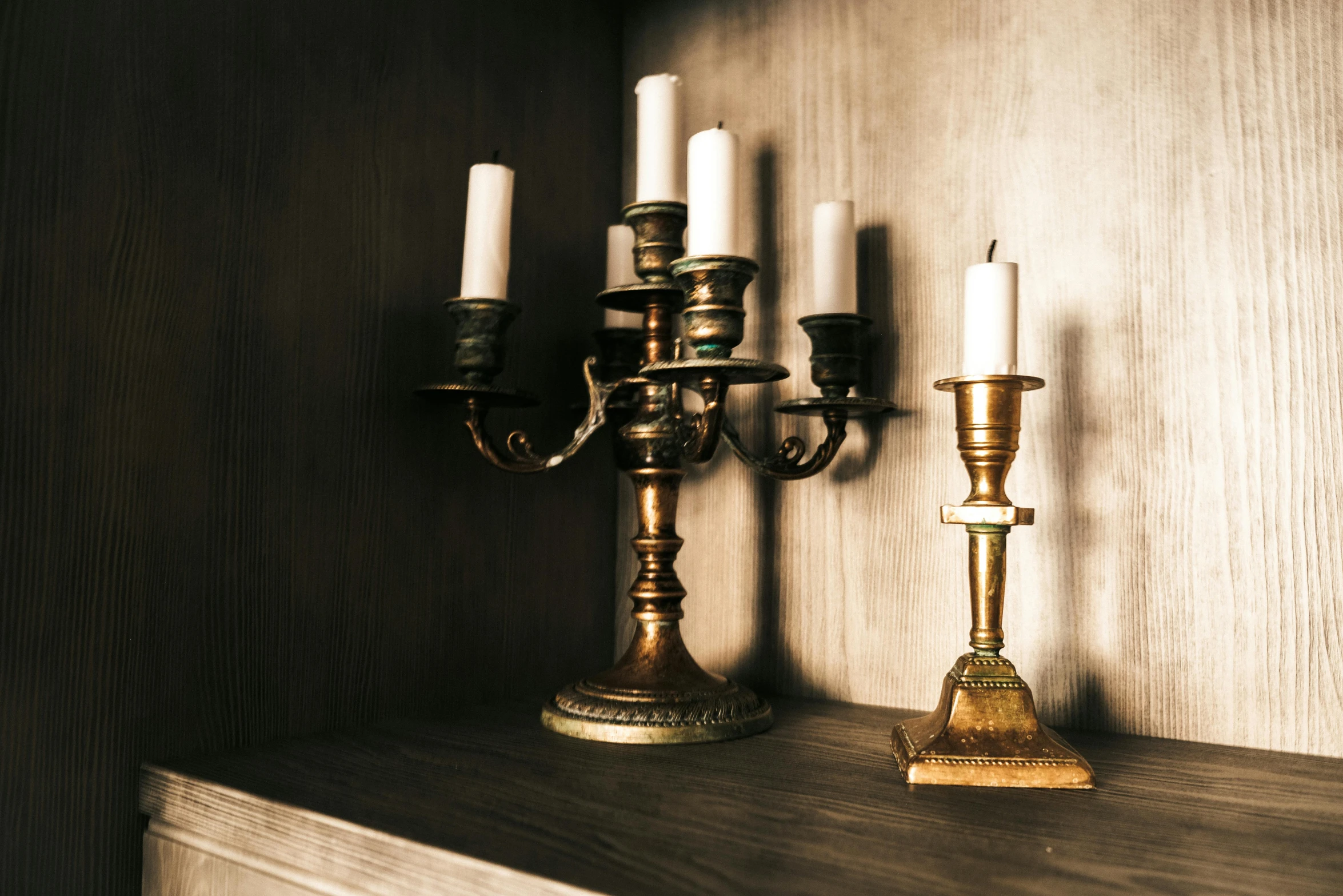 several lit candles on a wooden shelf