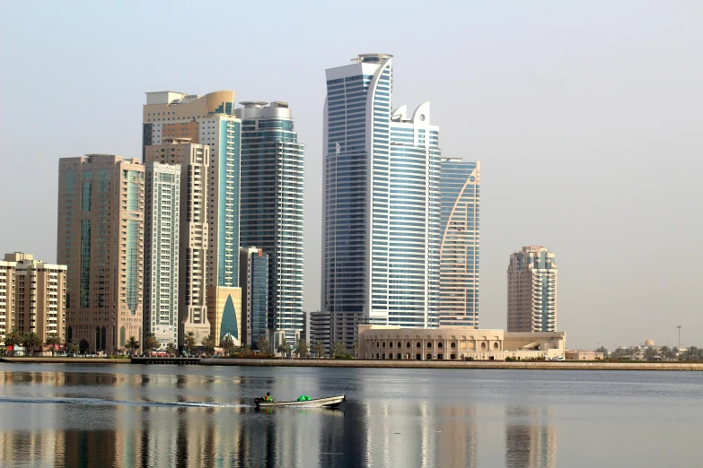 a boat in the water beside tall buildings