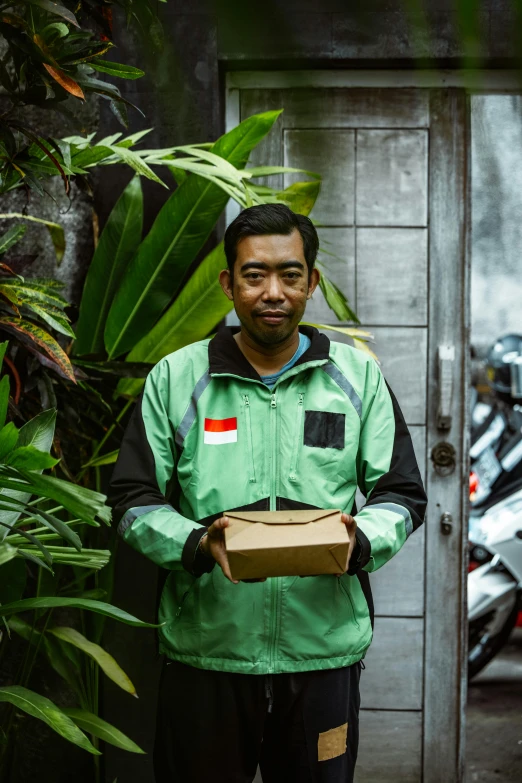 a man holds a box and an empty piece of cardboard