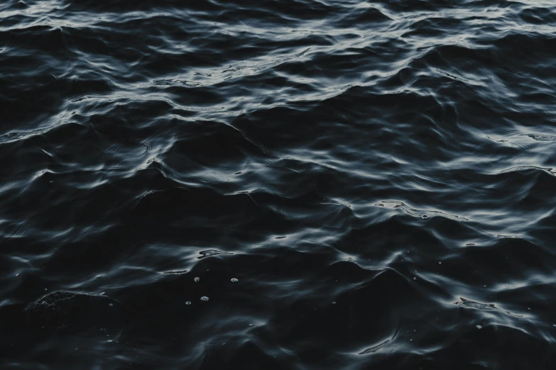 a dark colored ocean water with small waves