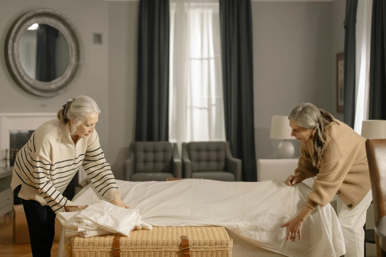 two older ladies unpacking a bed in the living room