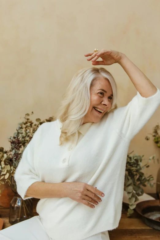 older woman standing next to a flower pot