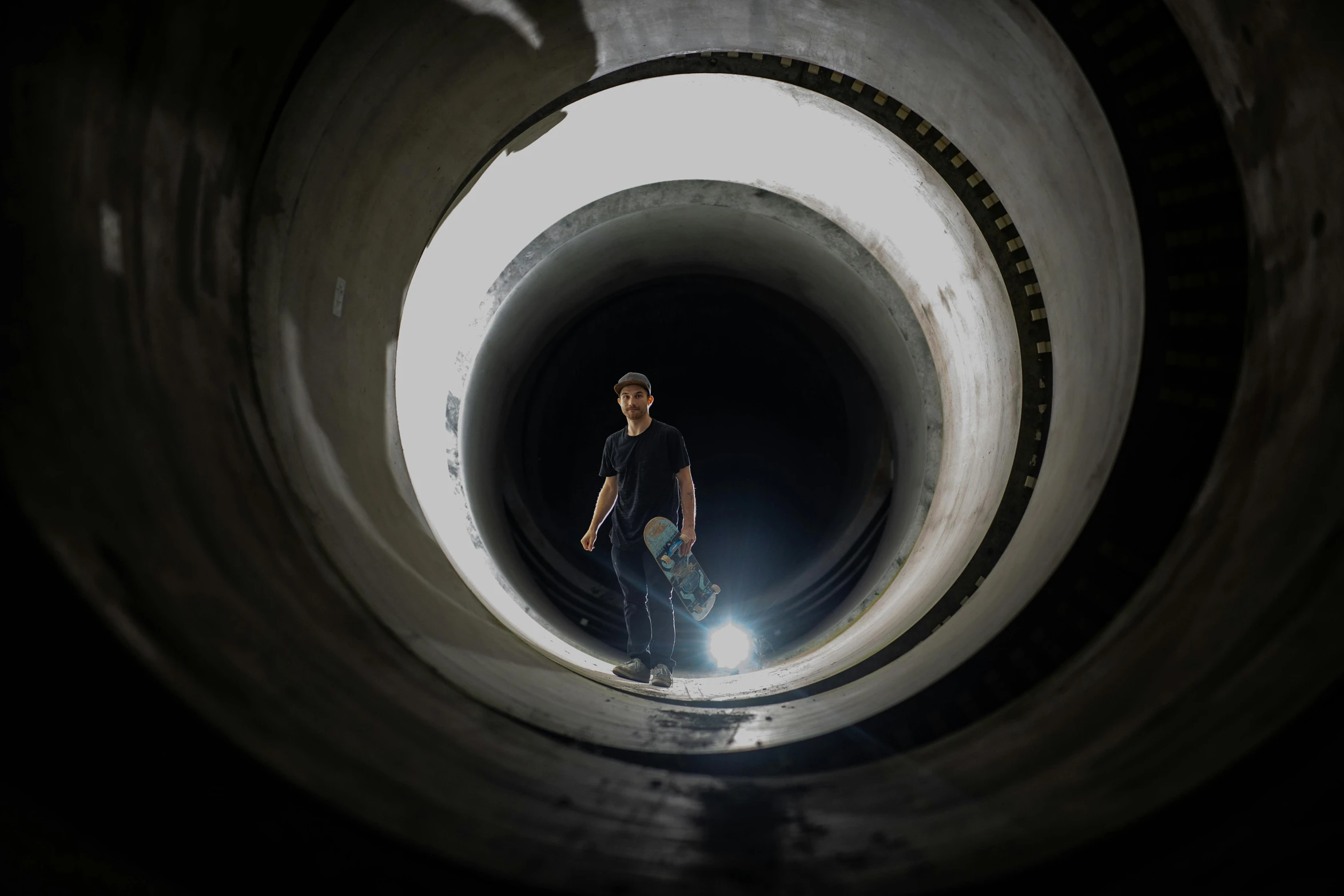 a man is standing in a very big pipe