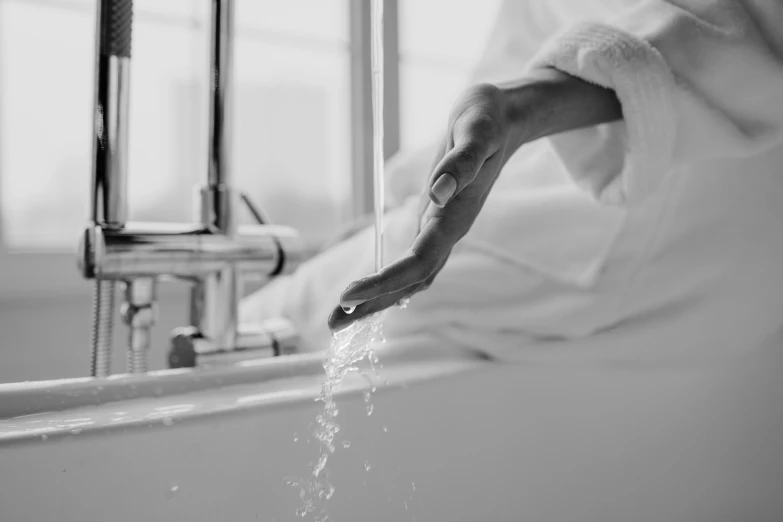 black and white po of a hand reaching out of a bathtub