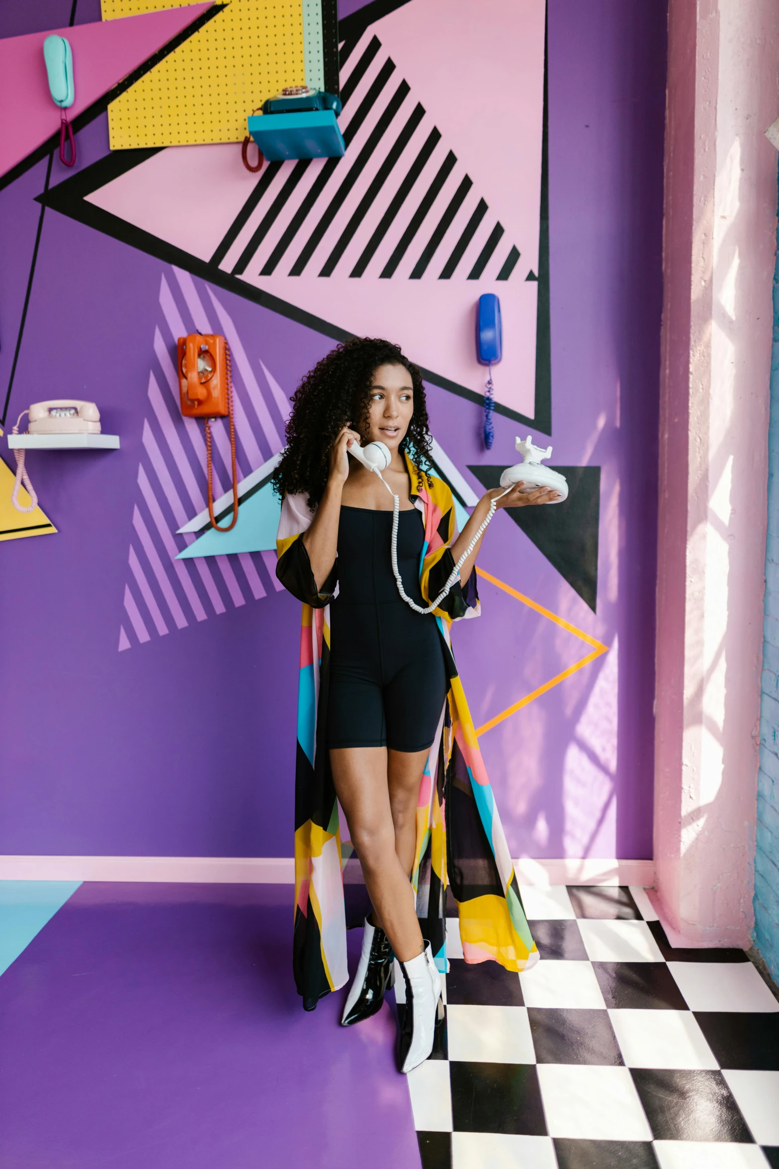 woman standing in colorful, art - deco room in black shorts