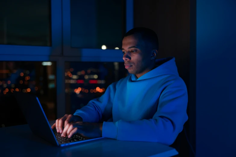 the young man is typing on his laptop