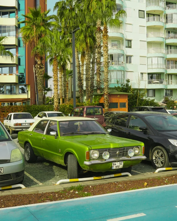 several cars lined up on the side of the road in a city parking lot