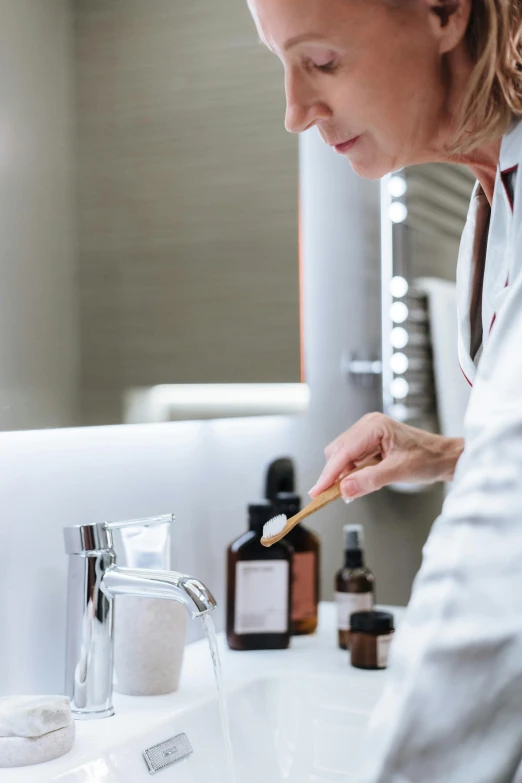 a person in a white robe holding a brush