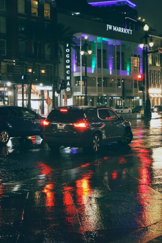 cars in a rain storm driving on a city street